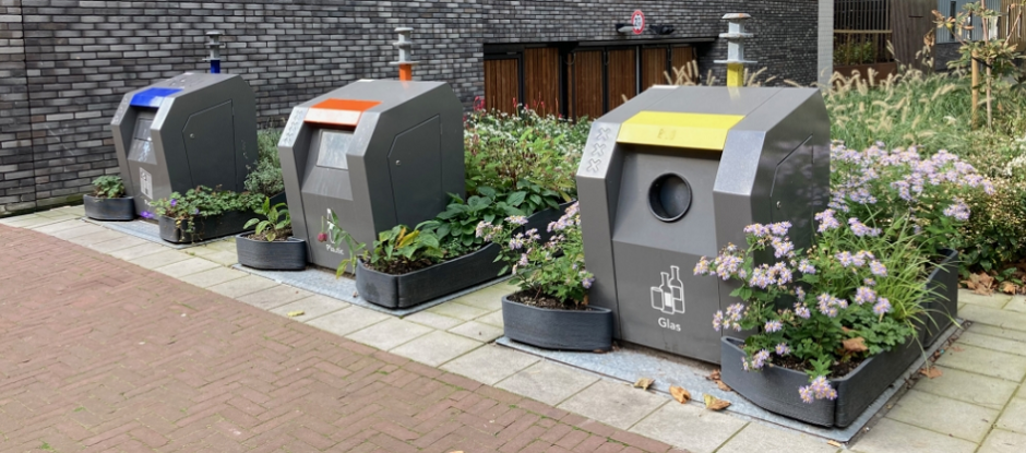 Photo of clean dustbins amongst flowers.